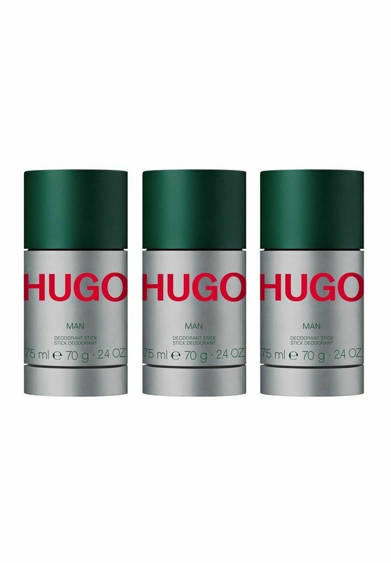 Tre deodoranter med gröna lock och silverfärgade behållare. Etiketten anger "HUGO MAN," med produktinformation i vit och grön text.