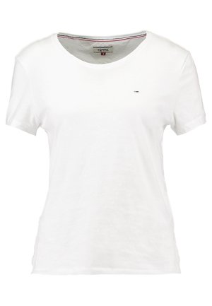 Biała koszulka z krótkim rękawem i okrągłym dekoltem, z małym logo Tommy Jeans na lewej piersi oraz markową metką wewnątrz kołnierza.