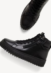 Crne kožne visoke tenisice s teksturiranom površinom, vezanjem sprijeda, bočnim patentnim zatvaračem i debelim gumenim potplatom s uzorkom za bolje prianjanje.