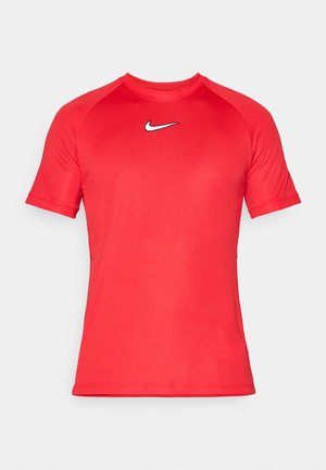 Czerwona sportowa koszulka z krótkim rękawem wykonana z gładkiego materiału. Posiada białe logo Nike na klatce piersiowej oraz fason raglanowy rękawów.