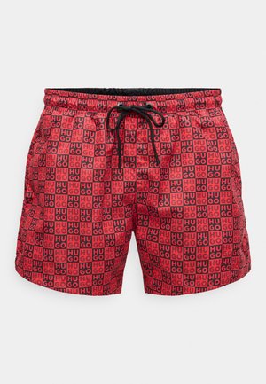 Rote Badehose mit grafischem Muster und dem Text "HUGO" in Schwarz, elastischem Bund mit Kordelzug und Seitentaschen.