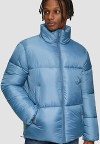 Lichtblauwe pufferjack met hoge kraag, horizontaal gestikt patroon, ritssluiting aan de voorkant en zijzakken. Gladde, glanzende stofstructuur.