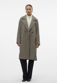 Dvostruko kopčani vuneni kaput u smešano-crnoj karo uzorak, s širokim reverima, oversized krojem i dva prednja dugmeta.