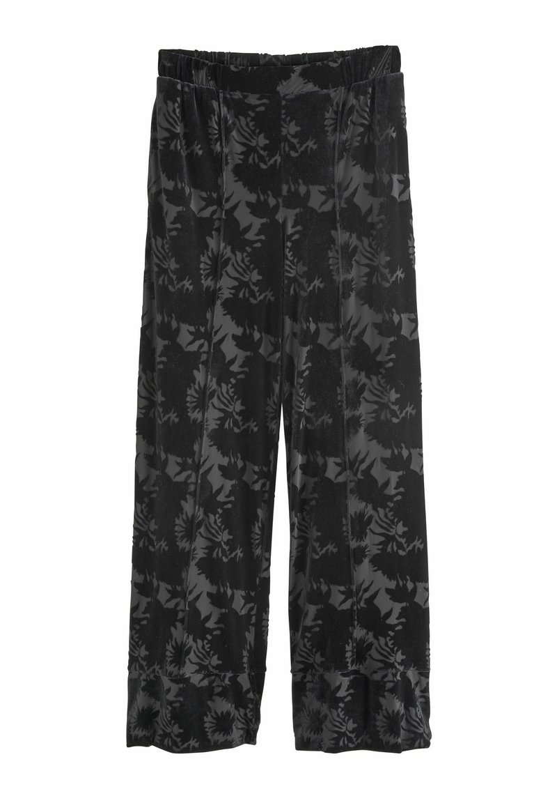 Pantalon large en velours noir avec taille haute et motif floral subtil, ceinture élastique et léger détail volanté sur l'ourlet inférieur.