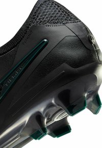 Scarpa da calcio nera con tomaia testurizzata in tessuto Flyknit, design elegante e accenti verdi sui tacchetti della suola di trazione.