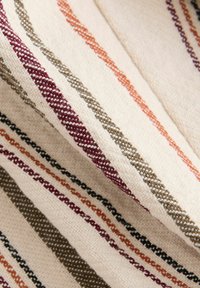 Tissu tissé avec des rayures alternées en lie de vin, orange, olive et noir sur un fond crème, avec une finition texturée.