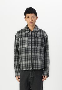 Gray and black plaid jacket with a zip closure, two front pockets, and a collared neck; features a soft, textured fabric.