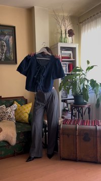 Ναυτικό μπλε cropped τοπ με κοντά μανίκια και κορδόνια μπροστά, συνδυασμένο με ανοιχτό γκρι ψηλόμεσες παντελόνες φαρδιάς γραμμής και μαύρες γόβες με μυτερή μύτη.