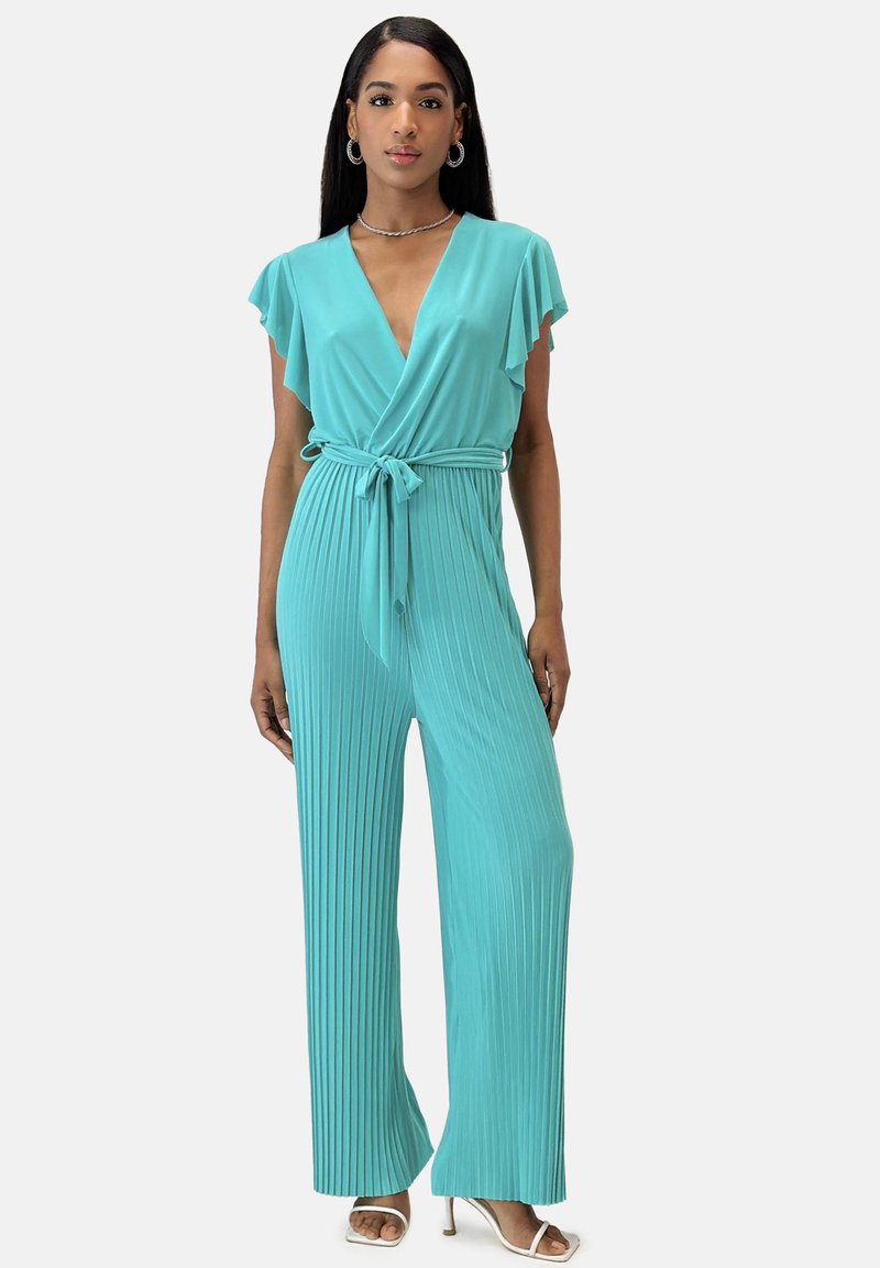 Turkos, plisserad jumpsuit med korta fjäderlätta ärmar och midjebälte. Har en djup V-ringning och breda, flödande ben.