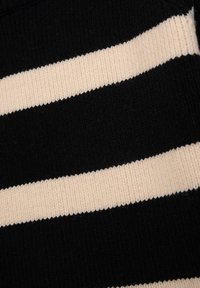 Schwarz- und cremefarbener, gestreifter Strickstoff mit geripptem Muster; abwechselnde breite und schmale Streifen.