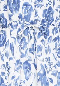 Valge kangas sinise lillemustriga, kujutatud erinevaid lilli ja lehti, vöökoht on kogutud ning seotud kangast vööga.