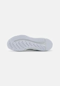 Sole di scarpa sportiva, prevalentemente bianca con grip in gomma testurizzata, caratterizzata da un motivo a diamante e solchi orizzontali per flessibilità.