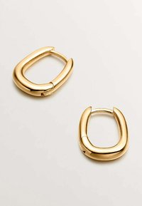 Pendientes de aro dorados con un diseño grueso y redondeado y un acabado pulido. Cuentan con un cierre seguro y un centro abierto que destaca su forma.