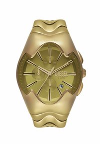 Montre Diesel avec un cadran vert olive, boîtier et bracelet en acier inoxydable doré, design en vague distinctif et affichage de la date à 6 heures.