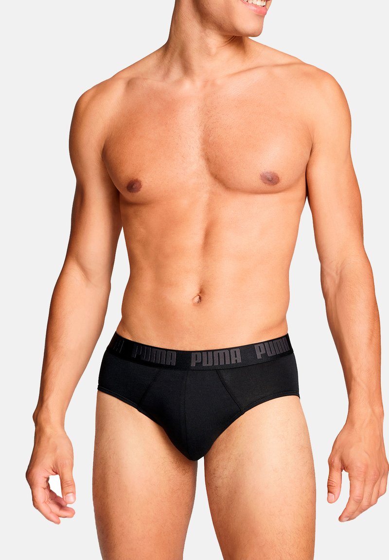 Schwarze Baumwollslips mit einem einfarbigen Design und einem elastischen Bund. Der Bund zeigt den Markennamen in kontrastierendem Schwarz.