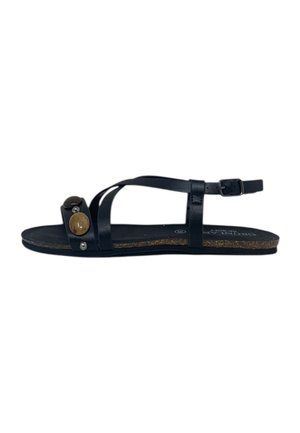 Sandalo piatto nero con sottili cinturini in pelle, fibbia alla caviglia e due borchie decorative rotonde sulla cinghia frontale.