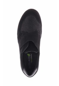 Zwarte schoen met een bovenkant van suède en textuuraccenten. Beschikt over een klittenbandsluiting en een rubberen zool. Inlegzool met het label "orthotrit" en een groen bladdetail.