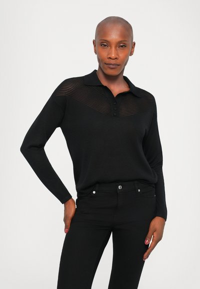 Black long-sleeve polo shirt with a textured yoke, three buttons at the collar, and a relaxed fit, paired with black fitted pants.