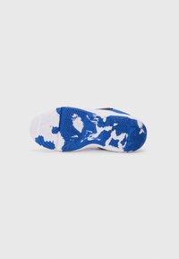 Suela de zapato deportivo negro con un patrón de goma azul y blanca, que presenta un agarre texturizado y un diseño de banda de rodadura distintivo. Materiales duraderos evidentes.