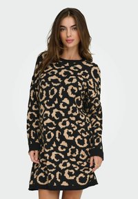 Robe en maille avec une base noire et un imprimé léopard beige, manches longues, col rond et coupe décontractée. Texture douce, longueur mi-cuisse.