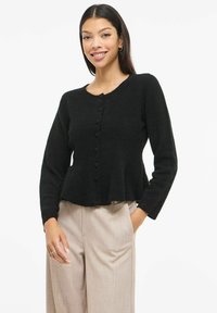 Melnā, piegulošā kardigana džemperis ar garām piedurknēm un pēpluma malu. Raksturīga apaļa apkakle un pogas priekšpusē. Mīksts materiāls.