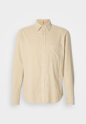 Beige Corduroy-Hemd mit langen Ärmeln, Kragen, aufgesetzter Brusttasche, Knopfverschluss und einer Struktur aus vertikalen Linien. Abgerundeter Saum und geknöpfte Manschetten.
