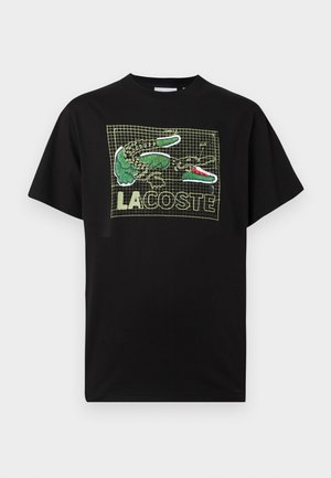 Μαύρο βαμβακερό T-shirt με μοτίβο πλέγμα, γραφικό πράσινου κροκοδείλου και κείμενο "LA COSTE" σε έντονες γραμματοσειρές σε όλη την επιφάνεια. Άνετη εφαρμογή.