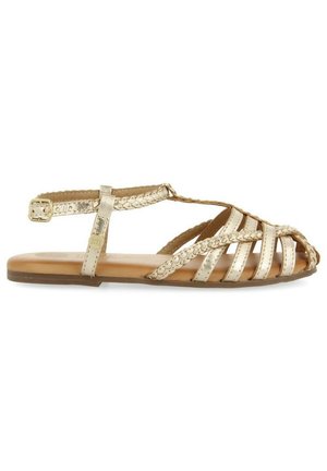 Sandalias metálicas doradas con tiras trenzadas, punta abierta y suela plana. Banda lateral en el tobillo con detalle de hebilla ajustable.