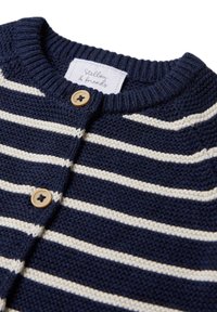 Navyblauer Strickcardigan mit weißen horizontalen Streifen, runder Ausschnitt, zwei Holzknöpfen und einem Stoffetikett.