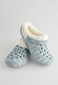 Lichtblauwe klompen met witte vospatronen en een fleece voering. Voorzien van ventilatiegaten en een gevormde vorm voor comfort.