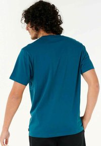 Kortærmet T-shirt med rund hals fremstillet af glat, letvægtsstof i teal, med et enkelt design og et mærke på den nederste venstre side.