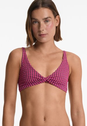 Roze en zwart gestippelde bikinitop met een verwrongen voorkant, dunne bandjes en een gestructureerde afwerking.