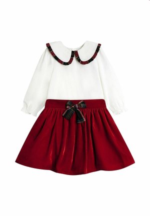 Weißes langärmliges Kleid mit großem Rüschenkragen, rotem Samtenrock und kariertem Schleifenband in der Taille auf einfarbigem Hintergrund.