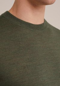 Green knitted sweater with a round neckline. The texture is smooth, featuring a subtle blend of lighter and darker green shades.