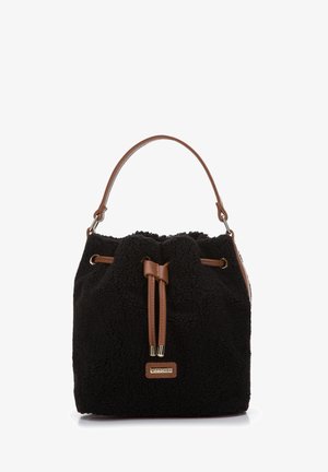 Černá umělá kožešinová kyblíková taška s hnědými koženými akcenty, vybavená stahovací šňůrkou a jedním horním madlem. Výrazná značka.