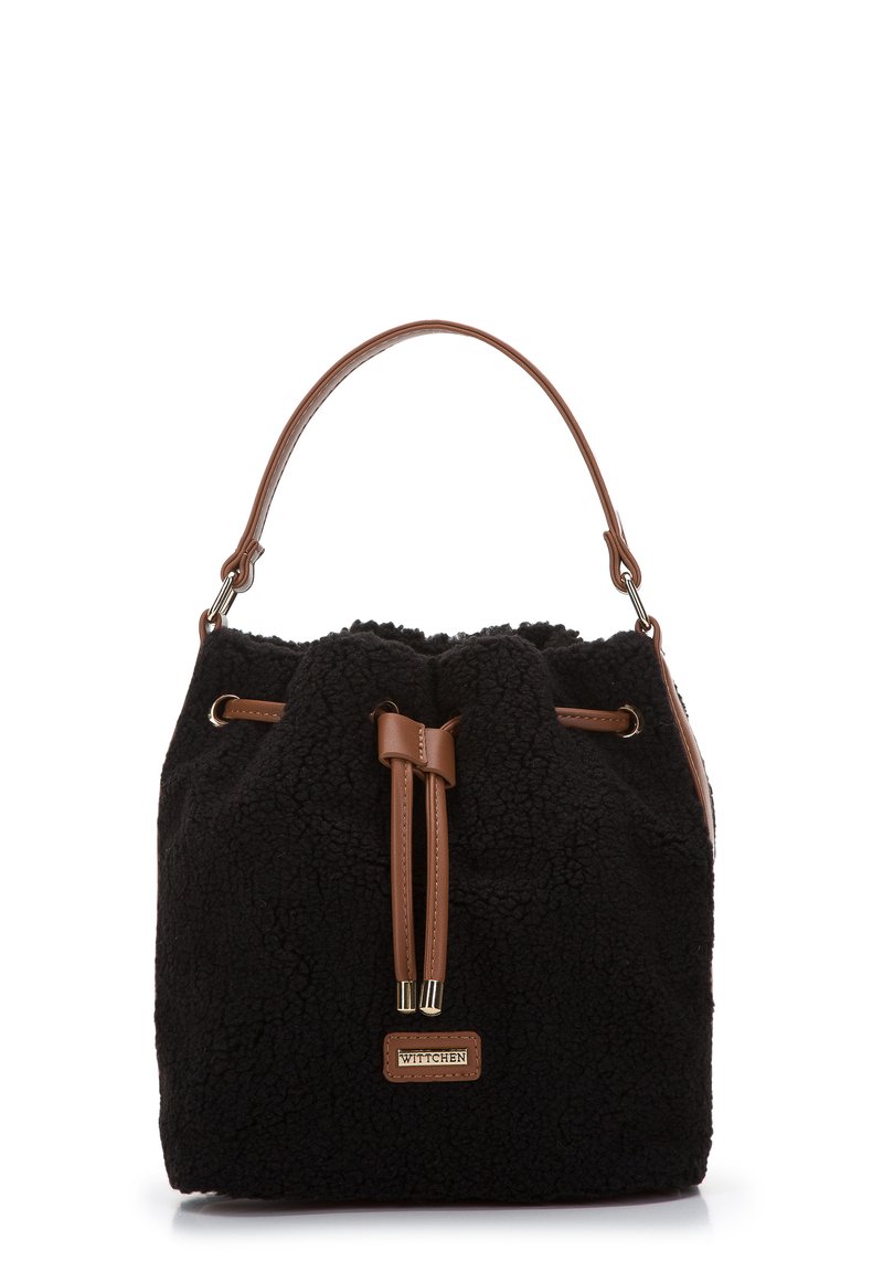 Sac seau en fausse fourrure noire avec des accents en cuir marron, présentant une fermeture à cordon et une seule poignée supérieure. Étiquette de marque remarquable.