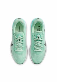 Scarpe da atletica verde menta con tomaia in rete testurizzata, lacci piatti e logo Swoosh Nike nero. Design leggero con suola ammortizzata.