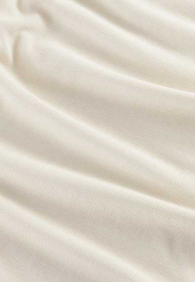 Strukturierter, cremefarbener Stoff mit einem dezenten Rippmuster, der sich sanft drapiert und aus weichem, leichtem Material besteht.