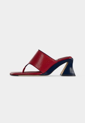 Sandale mule en cuir rouge à bout ouvert avec un talon bloc sculpté bleu marine et une bride tongs, vue de côté sur fond blanc.
