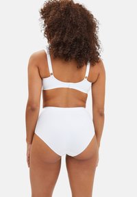Ensemble de soutien-gorge blanc et de lingerie taille haute, avec des bretelles réglables, une texture lisse et un matériel minimal pour un design épuré.