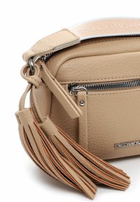 Borsa a tracolla in pelle beige con una finitura testurizzata, accessori in argento, tasca con zip e un accento decorativo in frange. Etichetta del marchio visibile sulla tracolla.