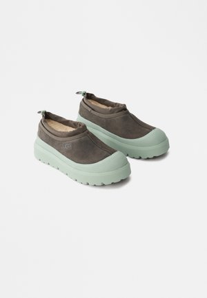 Cipele na slip-on s gornjim dijelom od smeđeg antilopa, mint zelenom gumenom potplatom, teksturiranim vrhom i elastičnim detaljima na peti za jednostavno obuvanje.