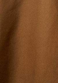 Tissu en coton marron avec une texture lisse et un léger éclat, affichant une teinte uniforme et douce sans motifs ni accents.