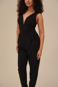 Svart jumpsuit med dyp V-hals og ermeløs design, tilpasset midje og vide ben med folder. Glatt stofftekstur.