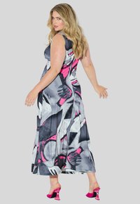 Maxime vestido em padrão abstrato cinza, branco e rosa; design sem mangas; tecido suave e leve; combinado com sandálias de salto rosa brilhante.
