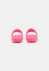 Pink open-back sandals with a smooth, matte texture, rounded shape, and perforated upper for breathability. Lightweight design, no visible accents.