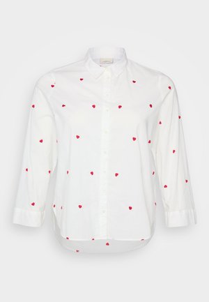 Camicia bianca con bottone e ricamo a forma di cuore rosso. Presenta maniche lunghe e un orlo leggermente curvo. Realizzata in tessuto di cotone leggero.