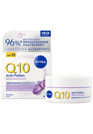Nivea Q10 Anti-Falten beruhigende Tagescreme mit LSF 15 in weißem Tiegel und Verpackung, mit lila Blumenmotiv und Produktangaben auf Deutsch.