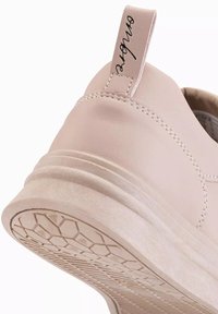 Baskets en cuir rose clair avec une semelle en caoutchouc texturé à motif hexagonal et une couture le long du talon ; présence d'une languette.