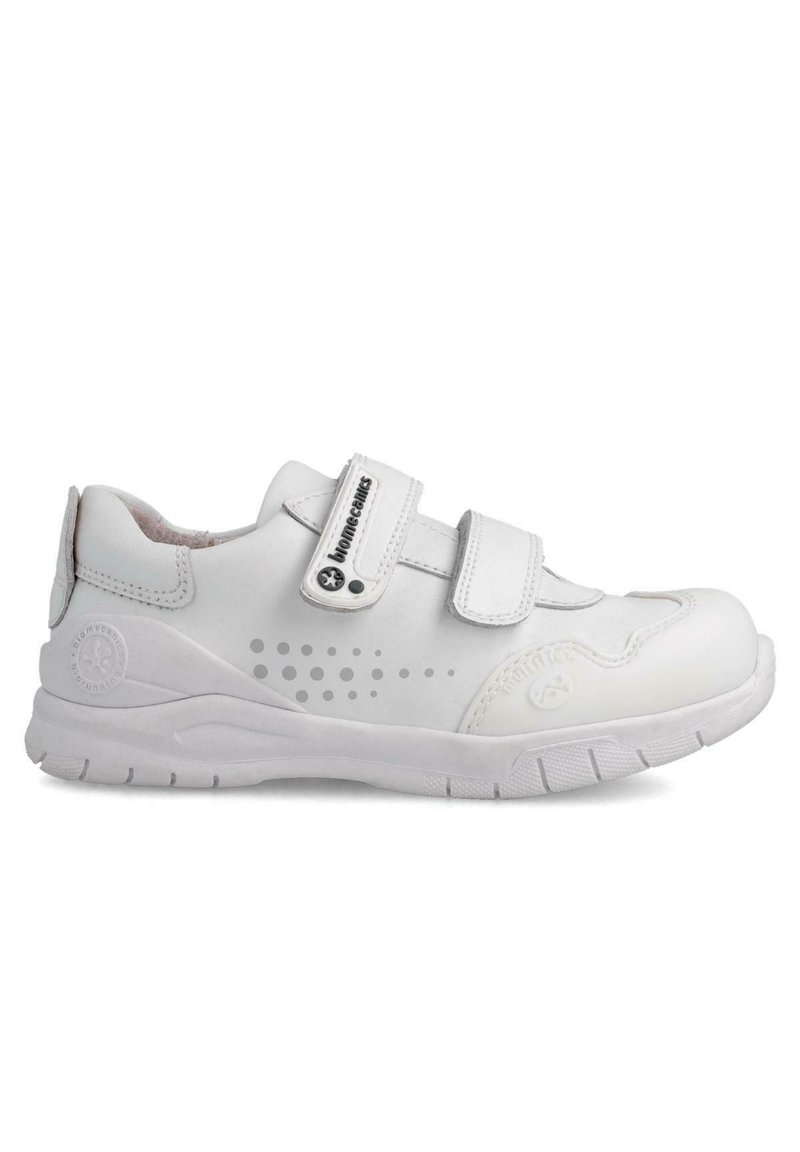 Zapatos deportivos blancos con dos correas de Velcro, diseño perforado en los laterales, cuello acolchado y suela de goma texturizada.